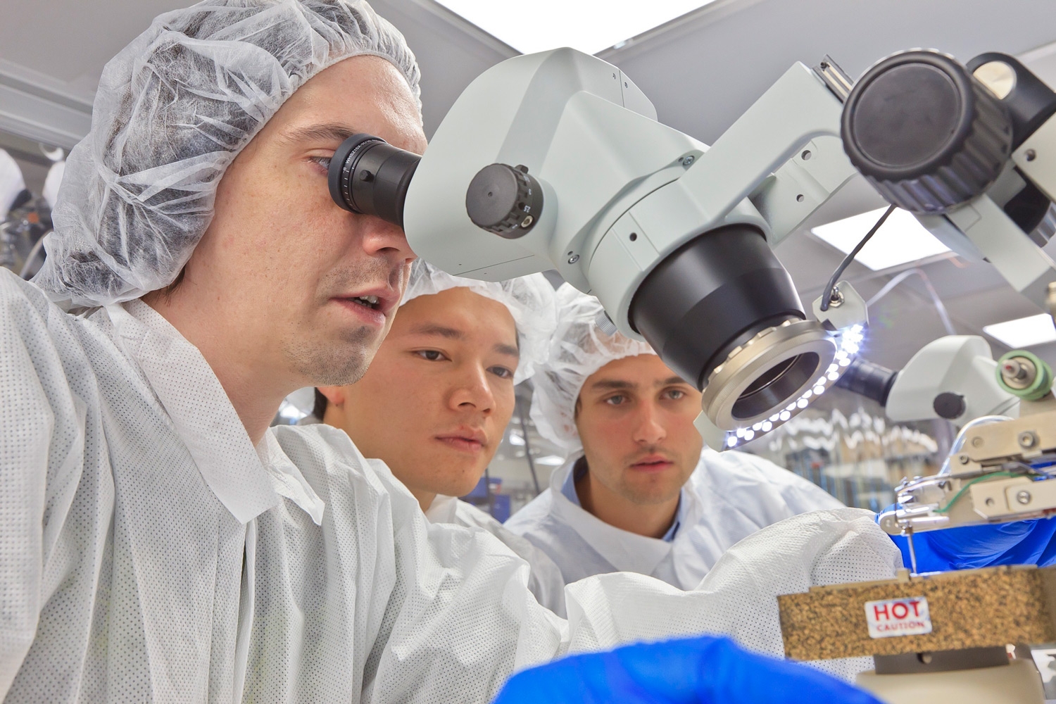 Science researchers looking through a microscope in the laboratory.