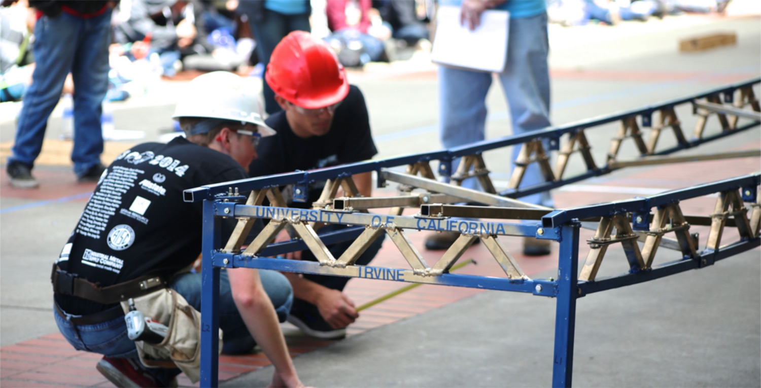 Two students in hardhats kneeling