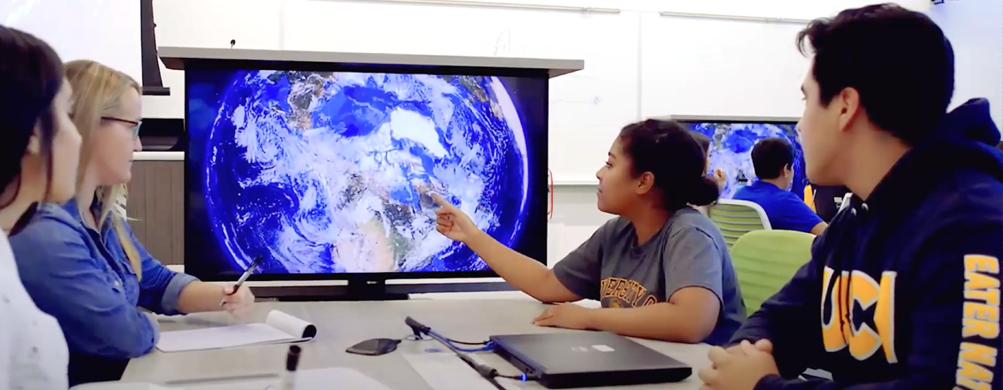 Students observing a representation of the Earth on a computer screen