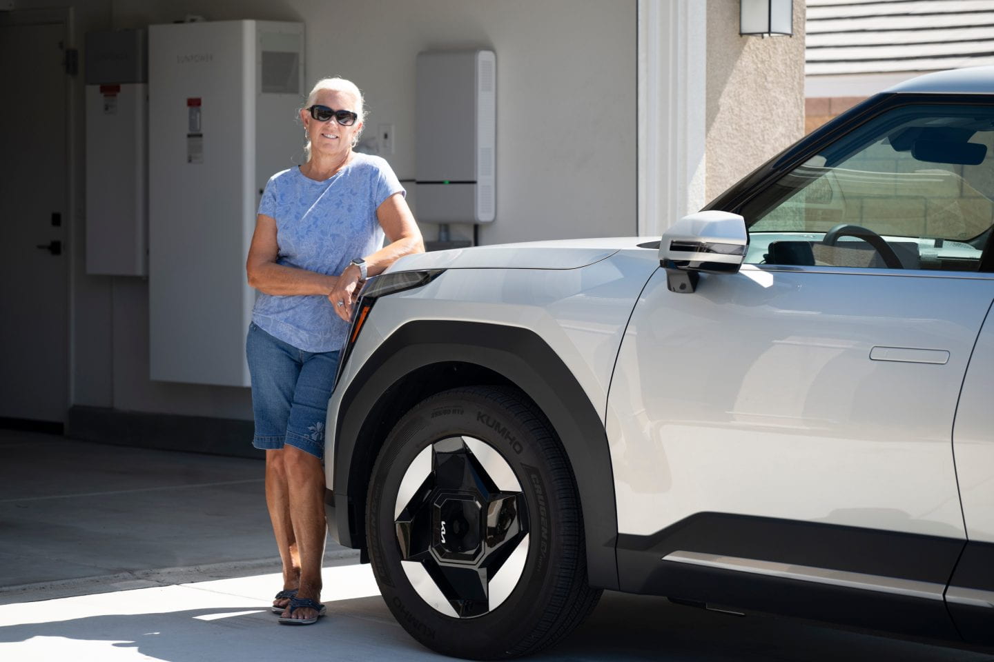 Woman standing next to car and garage